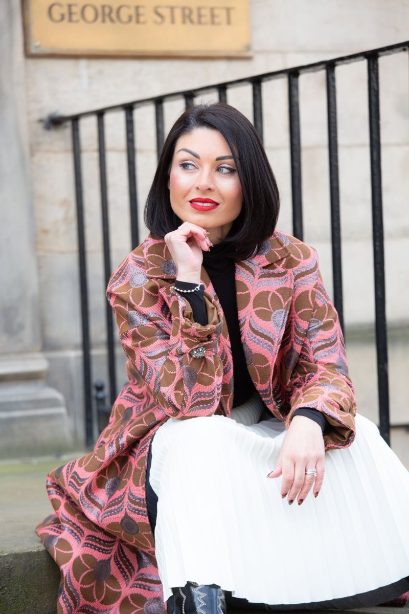 Business owner in a patterned coat on George Street steps