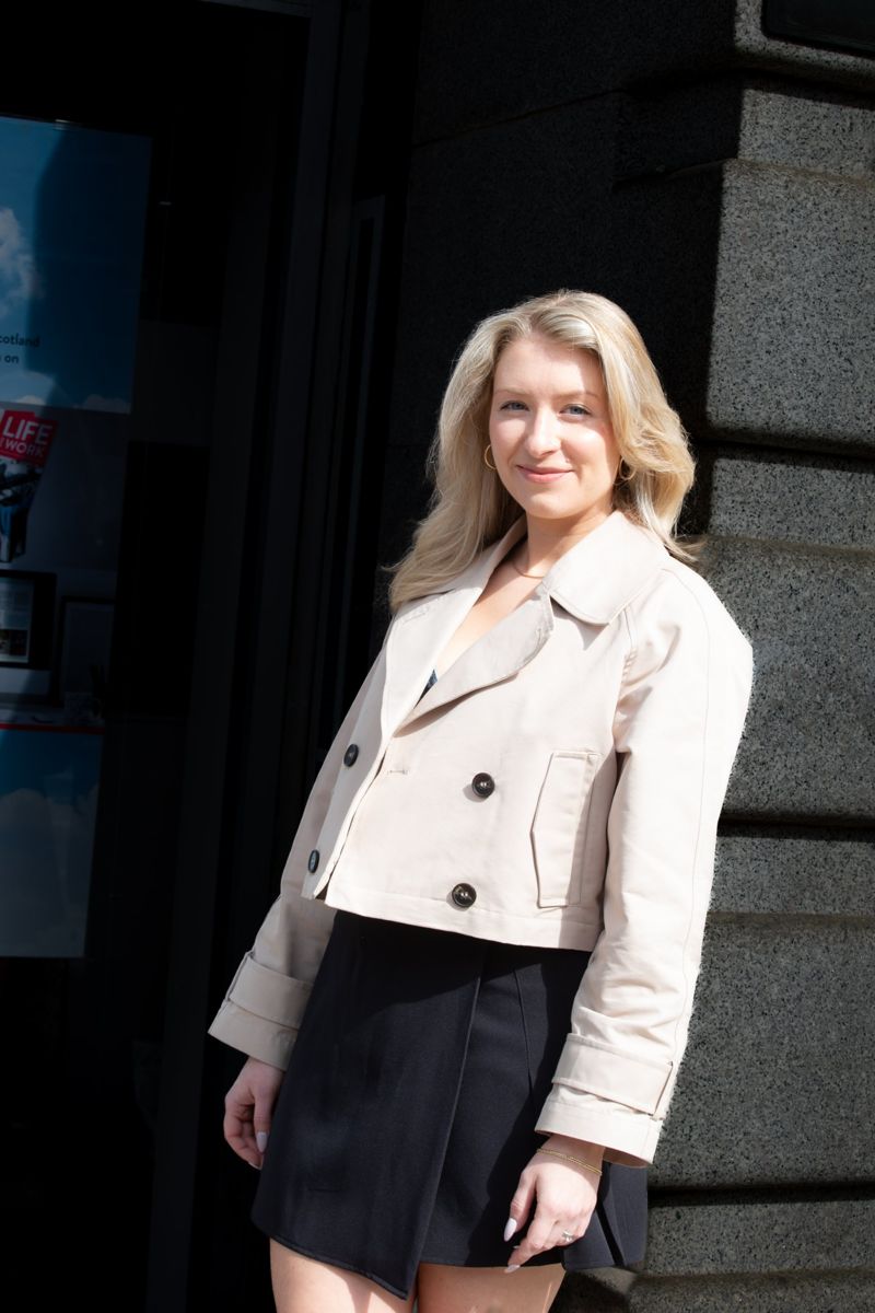 Business owner in a cream jacket on an Edinburgh street